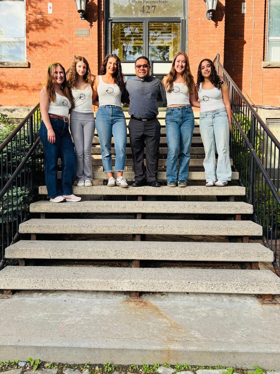 Il team del Gruppo Danza Fonte D'Amore con il parroco davanti all'ufficio parrocchiale di Sant'Antonio