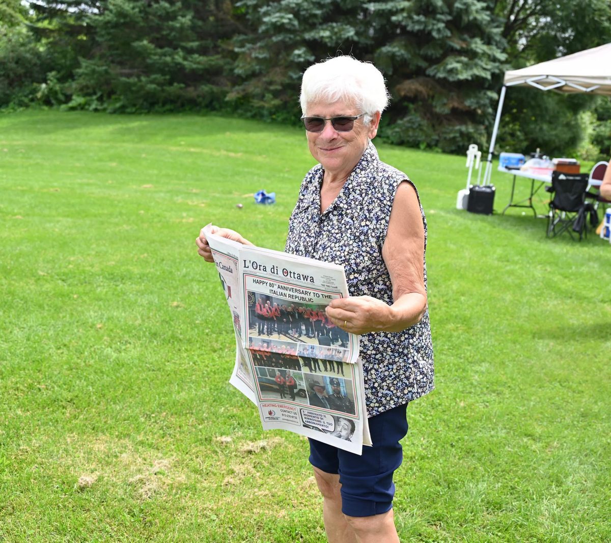 Una lettrice sfoglia L'Ora di Ottawa al picnic di Ferragosto
